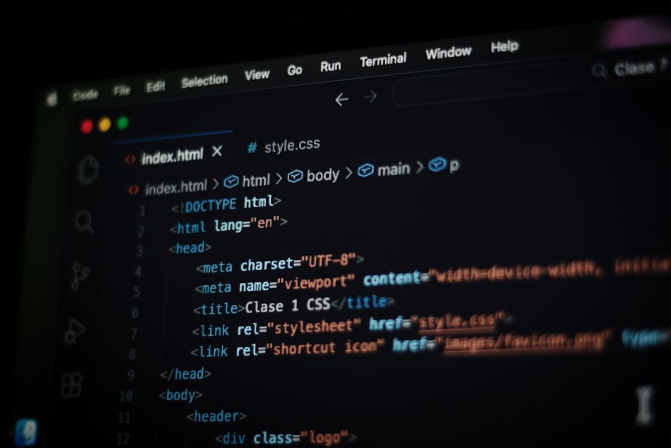 A close-up view of a laptop screen displaying lines of code in a text editor, with HTML and CSS syntax visible, alongside a simple digital calculator application with orange buttons for numbers and op